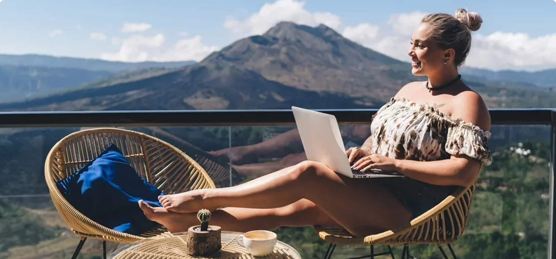 Mujer trabajando con su laptop frente a una montana